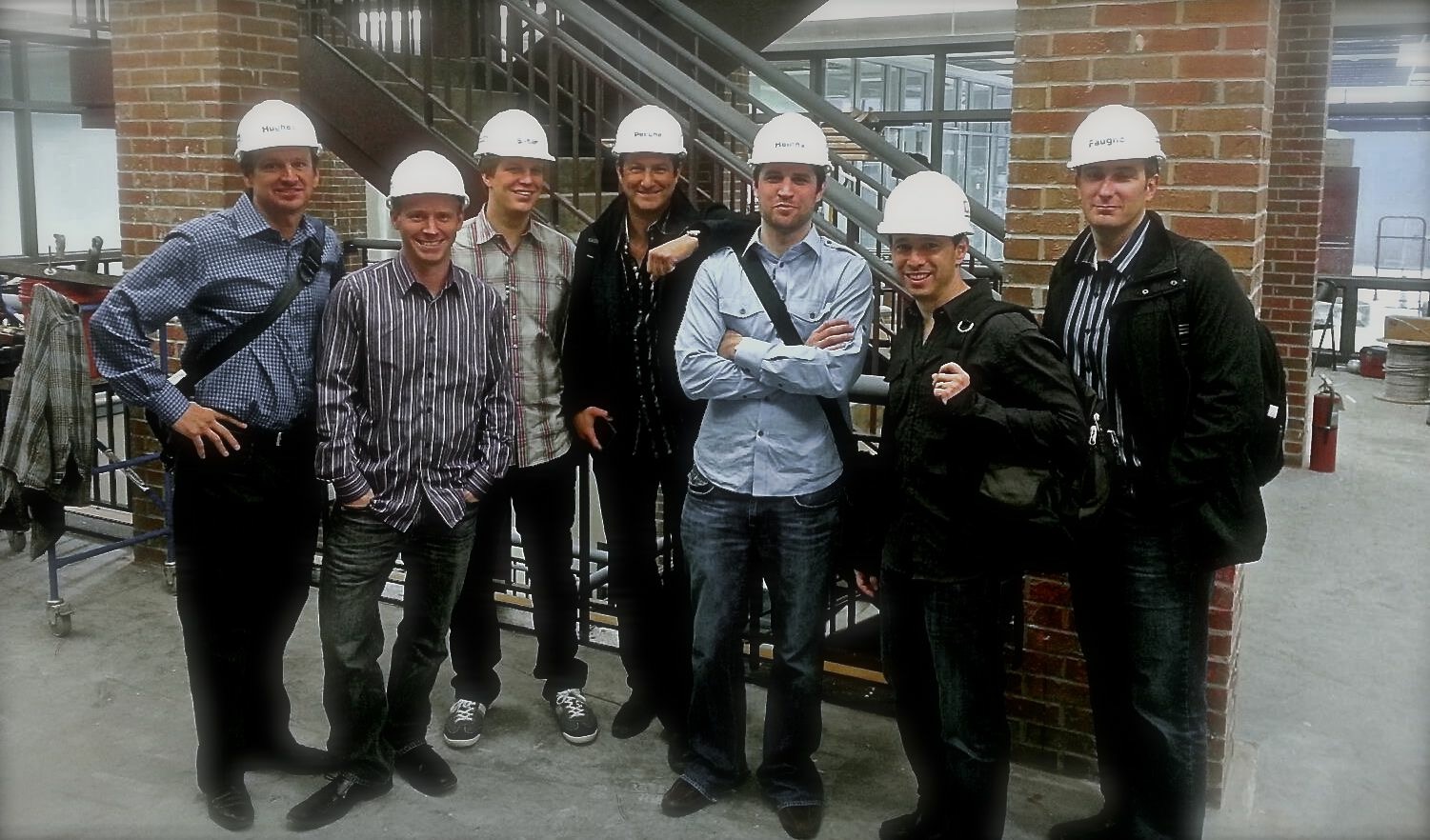 Sean Heiney and colleagues in hard hats inside the Ann Arbor building during its expansion construction