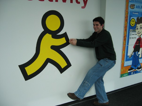 Sean Heiney at AOL headquarters, pulling the AIM running man logo off the wall, after AOL acquired DeadAIM